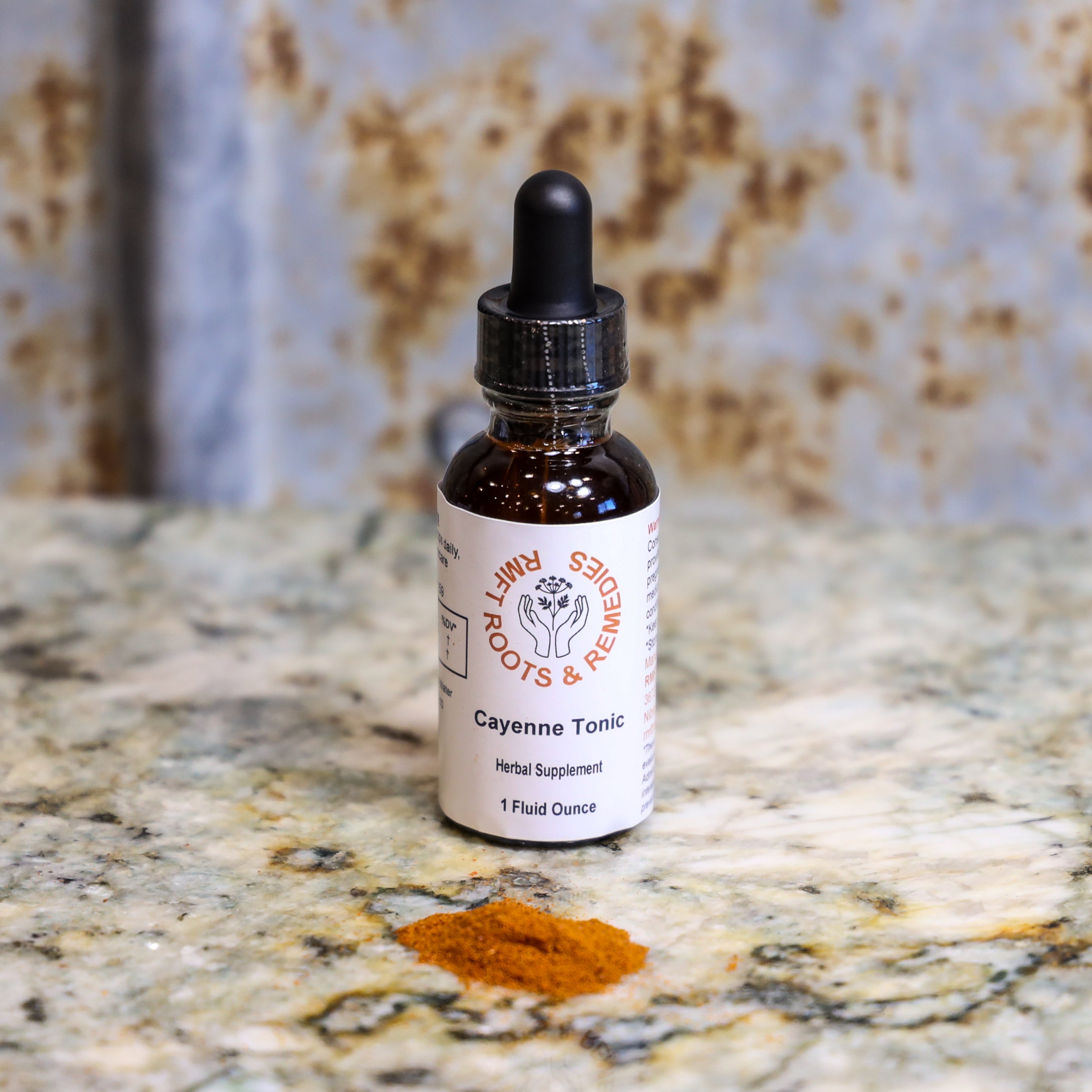 Bottle of Cayenne Tonic on a marble surface.