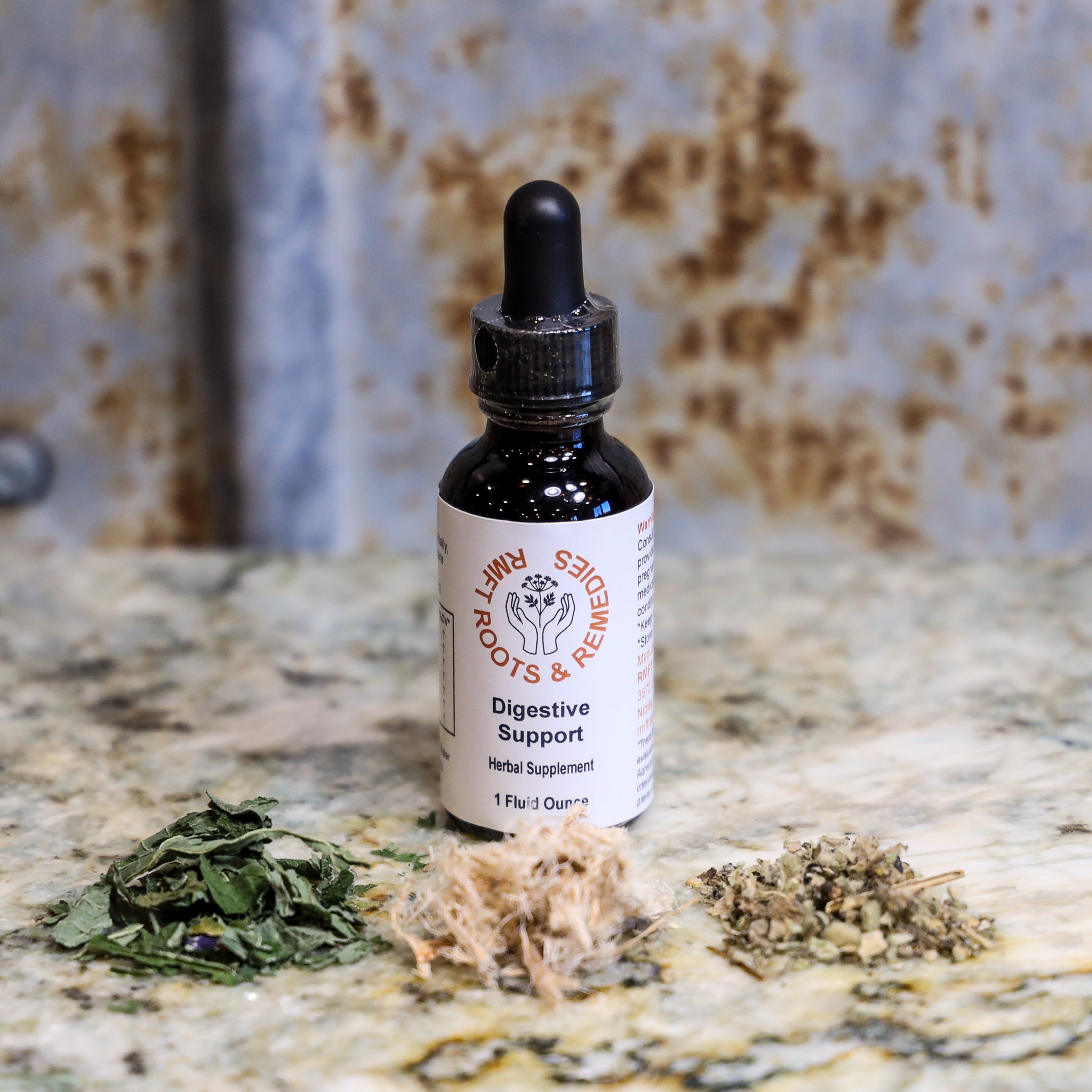 Bottle of digestive support supplement with dried herbs on a textured surface