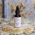 Bottle of 'Herbal Blood Support' supplement with dried herbs on a textured surface