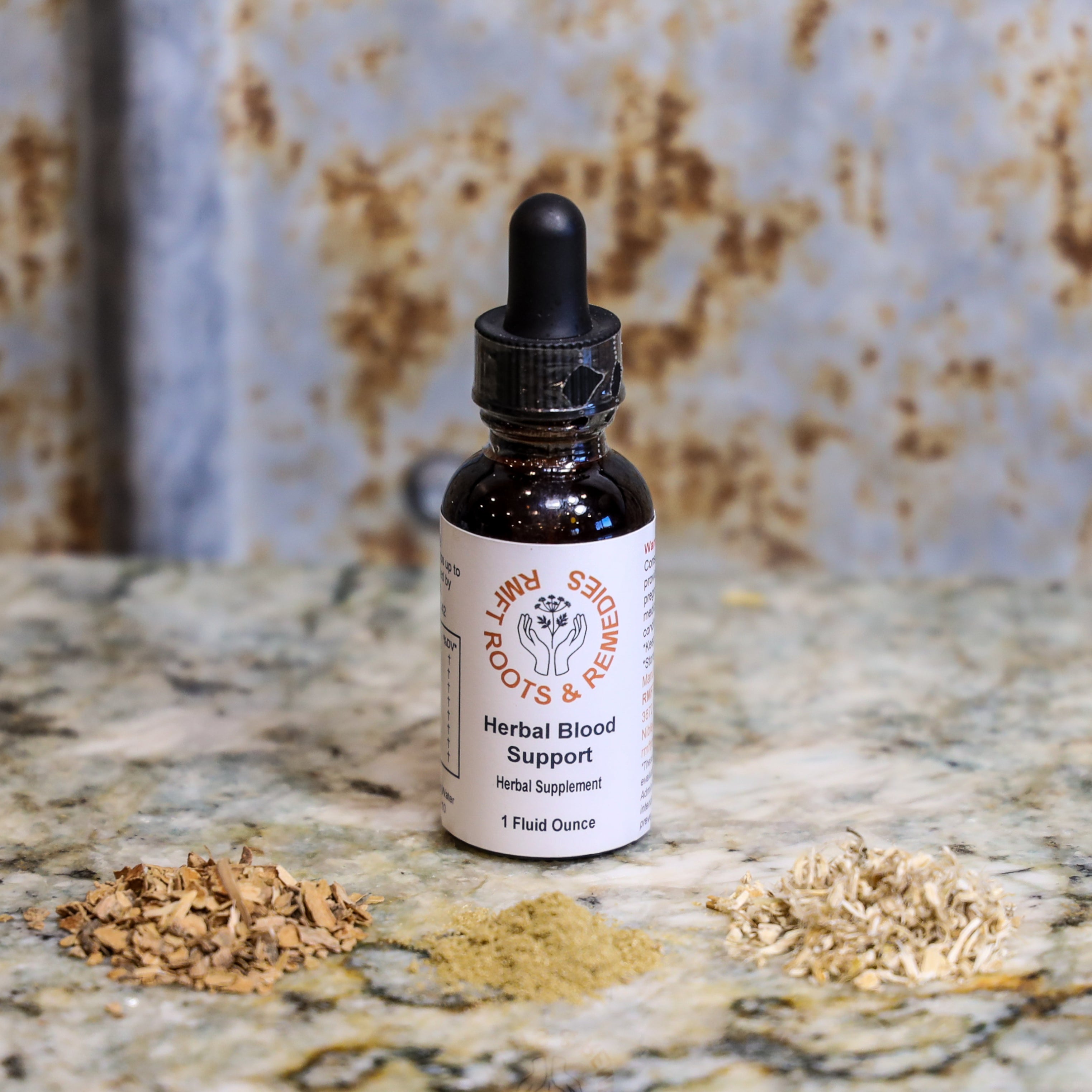 Bottle of 'Herbal Blood Support' supplement with dried herbs on a textured surface