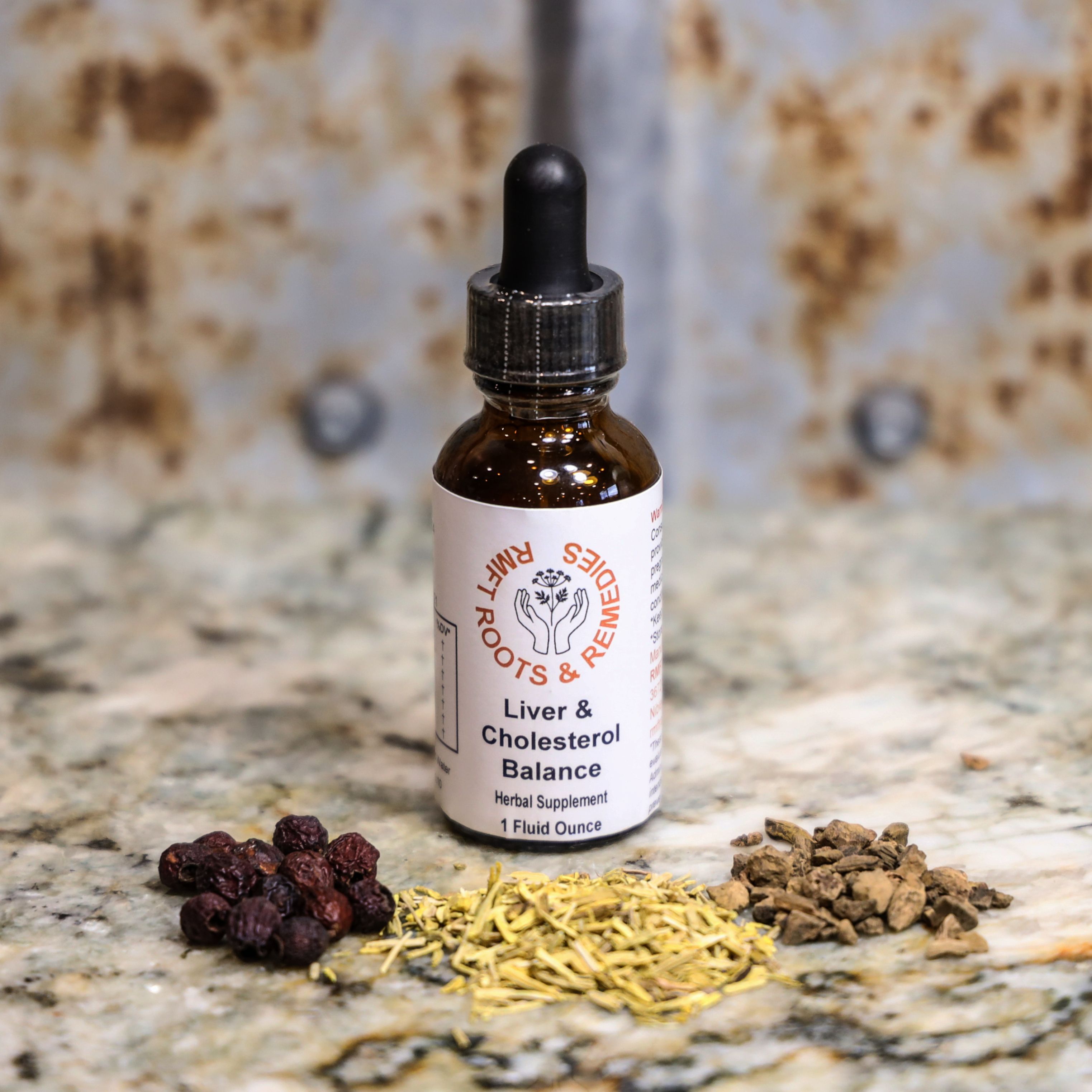 Bottle of 'Liver & Cholesterol Balance' herbal supplement with dried herbs on a textured surface