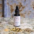 Bottle of 'Lymph Flow Support' herbal supplement with dried herbs on a textured surface.