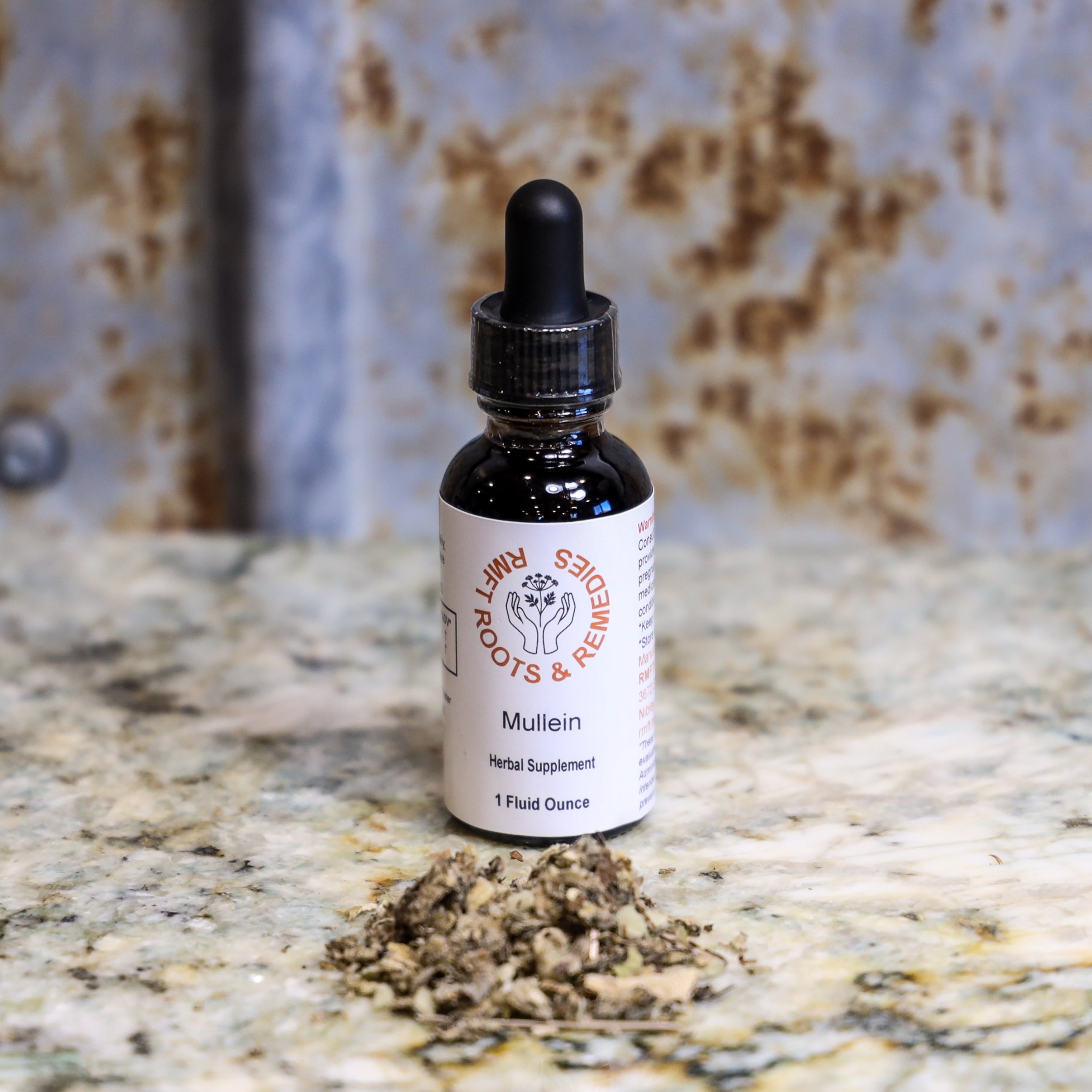 Bottle of Mullein herbal supplement with dried herbs on a marble surface